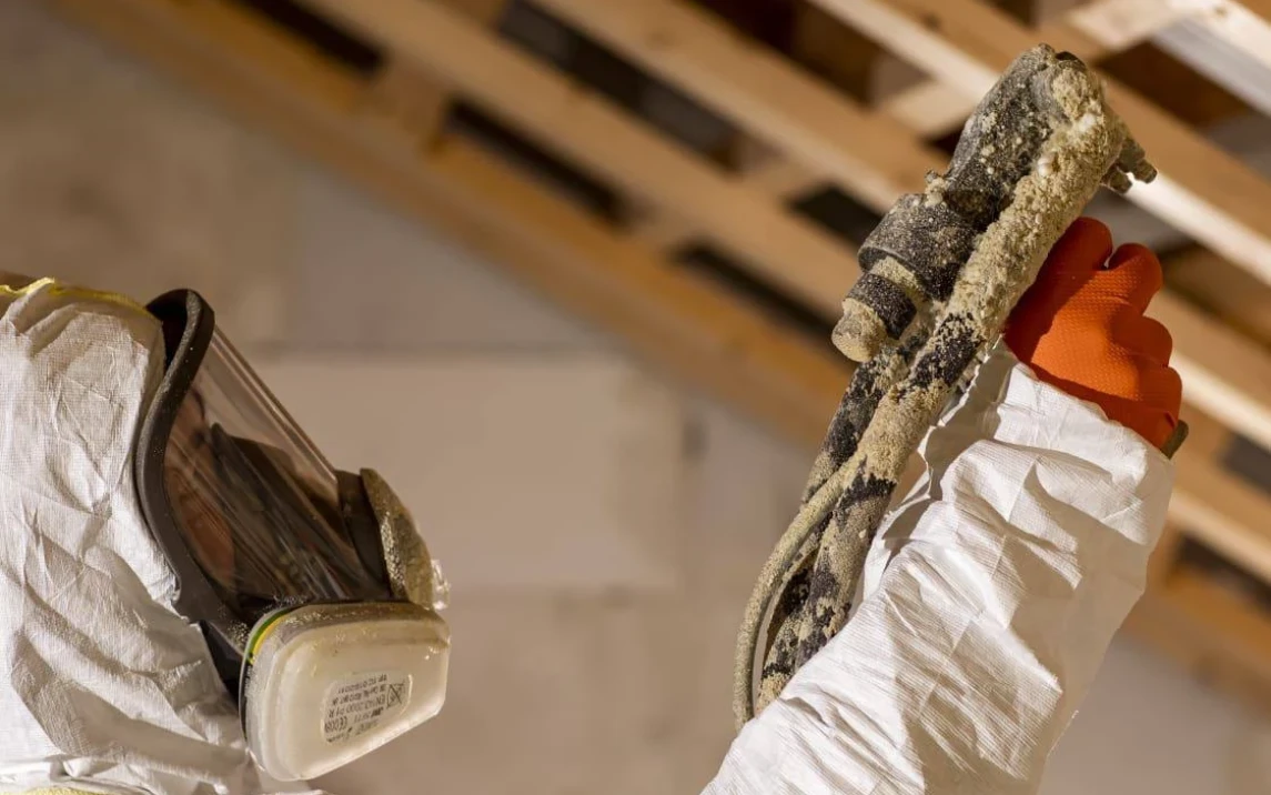 Pracownik w przybliżeniu rozkładający pianę termoizolacyjną 